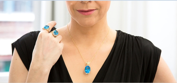 Modell trägt Schmuck mit blauem Topas in Gold